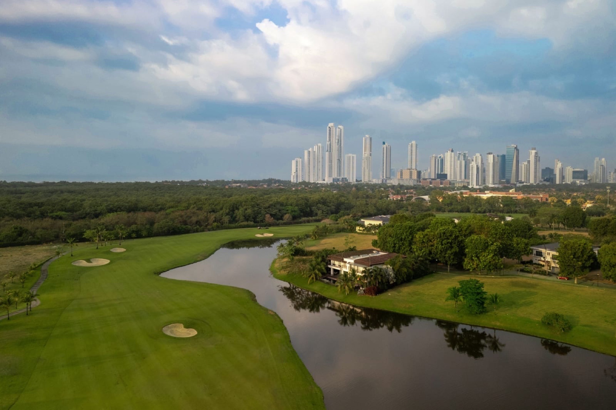 The Santa Maria golf course, its fairway curving along a lake with the Panama City skyline behind it